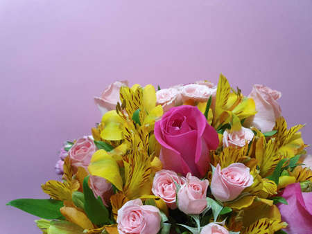 variety of flowers in a floral arrangement and pink backgroundの写真素材