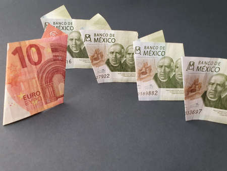 ten euro banknote between mexican 200 peso bills and black backgroundの写真素材