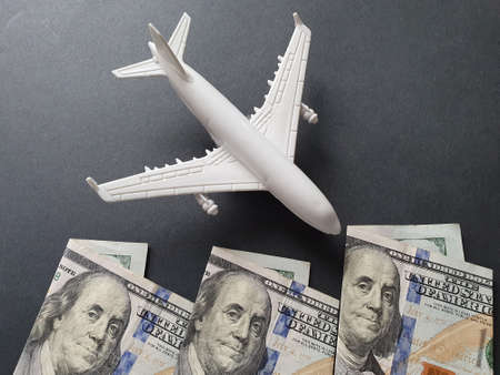 figure of a white plastic plane and american banknotes of 100 dollarsの写真素材