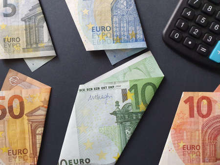 european banknotes of different denominations and calculator on the black backgroundの写真素材