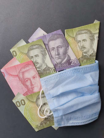 blue disposable mask and chilean banknotes of different denominations