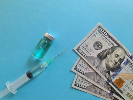 american dollar money, medicine bottle and syringe on the blue backgroundの写真素材