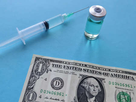 american banknote of one dollar, medicine bottle and syringe on the blue background