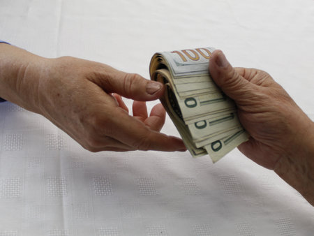 hands paying and receiving american dollar banknotes of different denominations