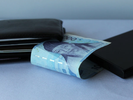 south korean money, black leather wallet and smartphone corner on the table