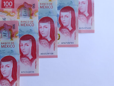 row of mexican 100 pesos bills on white background