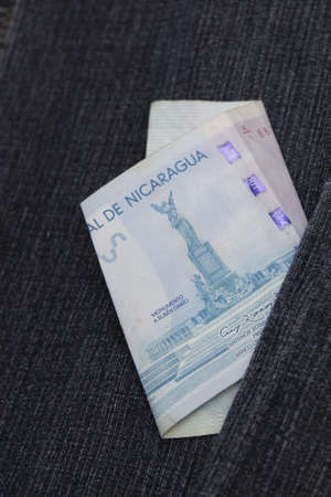 Nicaraguan banknote of 100 cordobas between blue denim fabricの写真素材