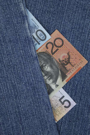 australian banknotes of different denomination between blue denim fabricの写真素材