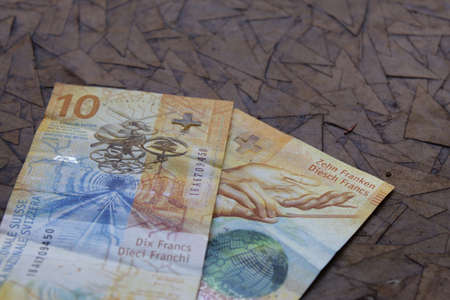 swiss banknotes of ten francs on the brown surfaceの写真素材