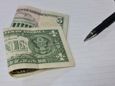 approach to american bills and pen on the white backgroundの写真素材