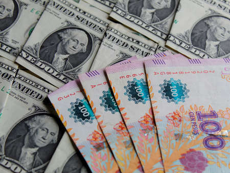 argentine banknotes of 100 pesos and american one dollar bills