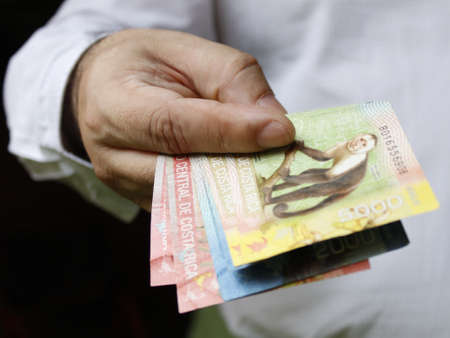 hand of a man holding Costa Rica banknotes