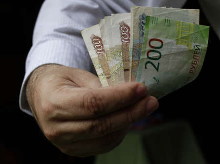 hand of a man holding russian banknotes of different denomination