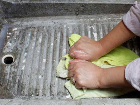 hands of a woman carving some cleaning cloths in a laundry room