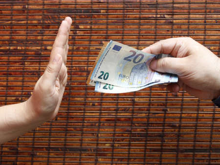 hand of a person giving european money and hand of another person rejectingの写真素材