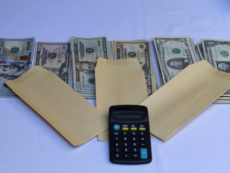 american dollars banknotes, yellow paper envelopes and calculator