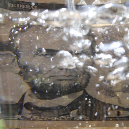 approach to american banknote of five dollars among the water bubbles