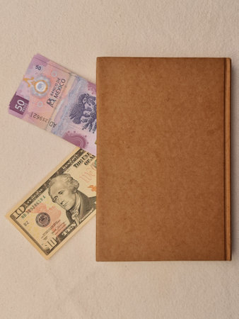 mexican banknote of fifty pesos, american ten dollars bill and brown book