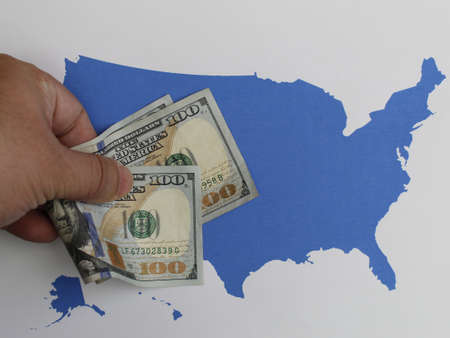 hand holding american dollars banknotes and USA mapの写真素材