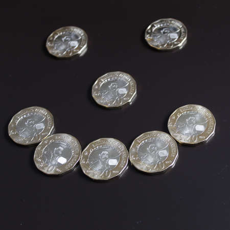 twenty mexican peso coins forming a happy face