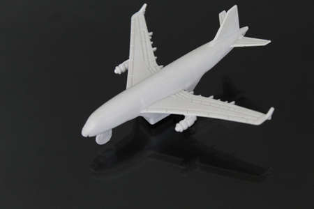 figure of a white plane on a glass table with reflection