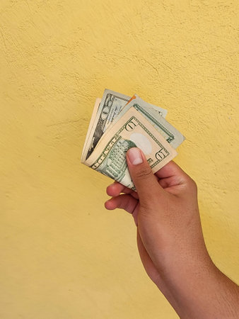hand of a man holding and paying with american dollars banknotes