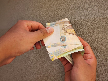 hands of a man holding and paying with peruvian banknotes