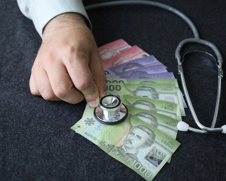 hand of a man with a stethoscope on chilean banknotesの写真素材