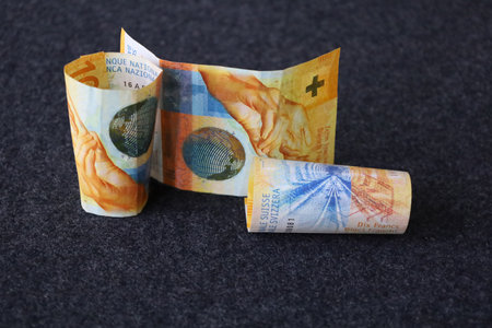 rolled swiss banknotes of ten francs on the tableの写真素材