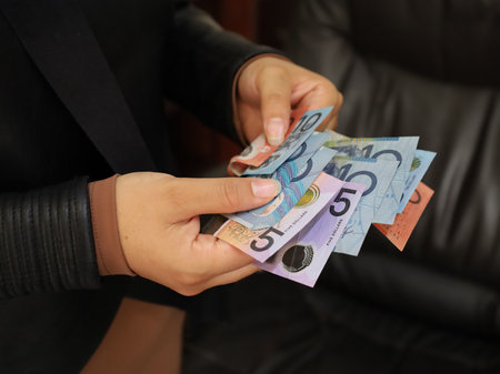 hands of a woman holding Australian dollars banknotes