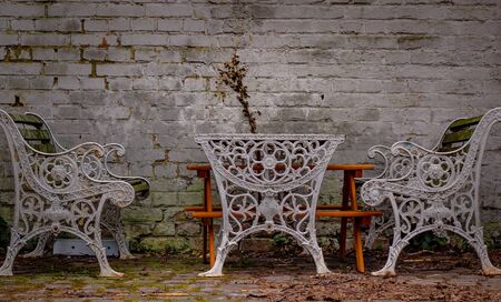 Vintage benches and table front of a wall