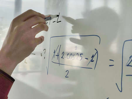 person writing on a white board