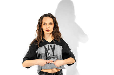 one slim brunette girl with long hair in a T-shirt with short shorts. girl covered her ears with her...
