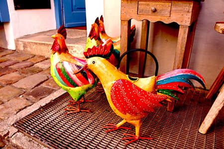 These are roster and hen shaped garden ornaments displayed outside a shop in Mittenwald, Bavaria, Germany.の写真素材