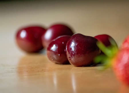 Dark red cherries on varnished wooden table