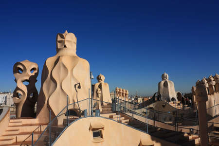 On the terrace of the Casa Mila (also called La Pedrera) is a cross-shaped chimneys and soldiers of anthropomorphic forms created by Antonio Gaudi. It was created in 1905. Photo background.の写真素材