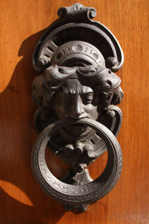 Metal knocker shaped woman. In a door in the middle of the city of Florence, Italy