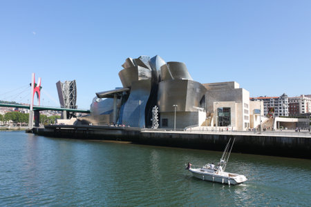 BILBAO, MAY 22: A boat crosses the Nervion river in front of the Guggenheim Museum on May 22, 2010 in Bilbao, Spain. Guggenheim Museum is a design by architect Frank O. Gehry.のeditorial素材