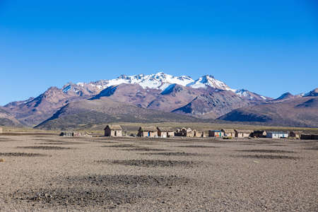 Small village of shepherds of llamas in the Andean mountains. High Andean tundra landscape in the mountains of the Andes. The weather Andean Highlands Puna grassland ecoregion, of the montane grasslands and shrublands biome,の写真素材