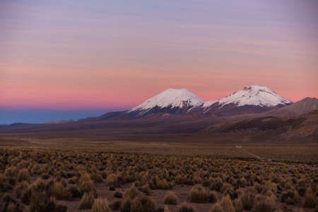 Sunset in Andes. Parinacota and Pomerade volcanos. High Andean landscape in the Andes. High Andean tundra landscape in the mountains of the Andes.の写真素材