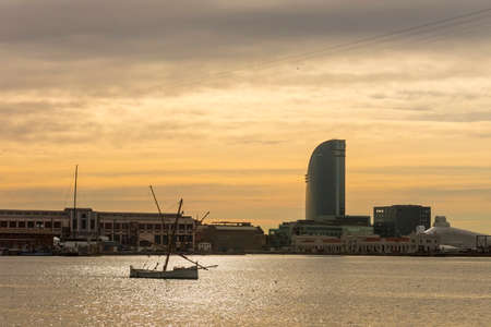 Sunrise at the port of Barcelona, at the end of the Ramblas. In the photo, a fishing boat and sailing hotel. Barcelona, Spainの写真素材