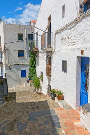 Typical white and narrow Mediterranean street, in the small fishing village of cadaques, typical Mediterranean village on the Costa Brava of Spainの写真素材