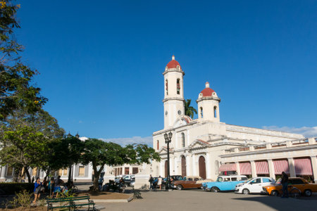 CIENFUEGOS, CUBA - JANUARY 3, 2017: Old cars parked in the Jose Marti Park, the main square of Cienfuegos, in front of the Purisima Concepcion Cathedral. City of Cienfuegos, island of Cuba.のeditorial素材