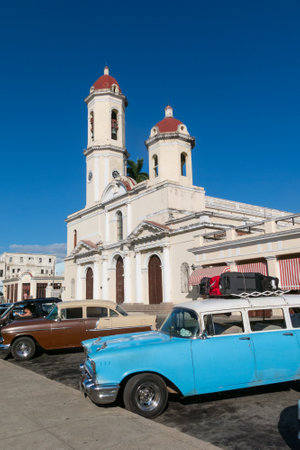 CIENFUEGOS, CUBA - JANUARY 3, 2017: Vintage cars in Jose Marti Park, the main square of Cienfuegos, in front of the Purisima Concepcion Cathedral. Cienfuegos, island of Cuba.のeditorial素材