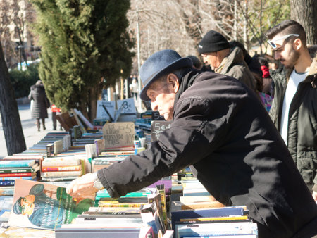 Madrid, Spain - January 27, 2018: Old men flipping through books Antique Book Store in Moyano's slope near the Buen Retiro Park, Madrid, Spainのeditorial素材