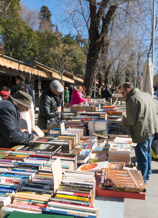 Madrid, Spain - January 27, 2018: People walking and flipping through books Antique Book Store in Moyano's slope near the Buen Retiro Park, Madrid, Spainのeditorial素材
