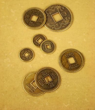 Chinese feng shui coins for good fortune and success in old and worn textile backgroundの写真素材