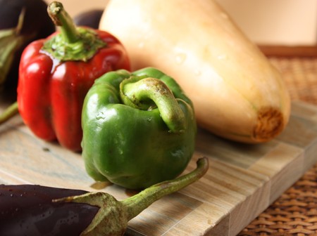 Fresh baby vegetables over cutting boardの写真素材