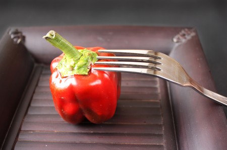 Fresh baby red pepper on black plate with forkの写真素材