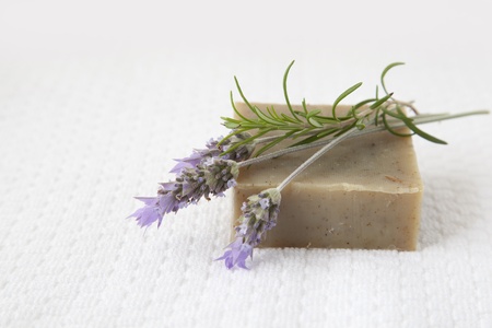 Homemade soap with lavender and rosemary over white towel backgroundの写真素材